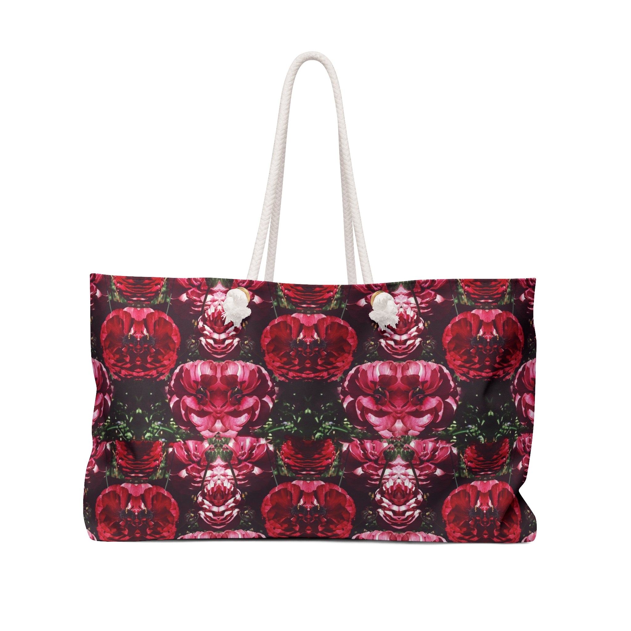 A weekender tote bag with a floral pattern in red and dark colors, featuring white handles.