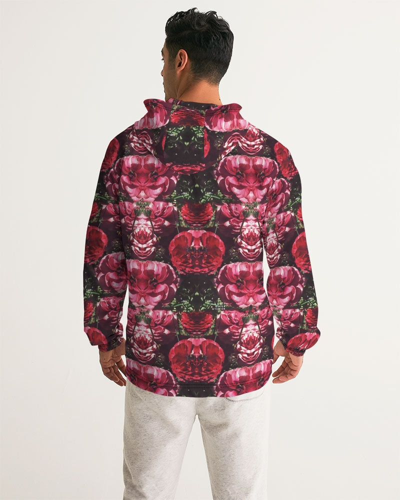 A man wearing a floralis no 25 men’s windbreaker with a mirrored pink and red rose pattern on a black background
