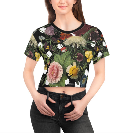 Woman wearing a black crop top with colorful floral design on a white background