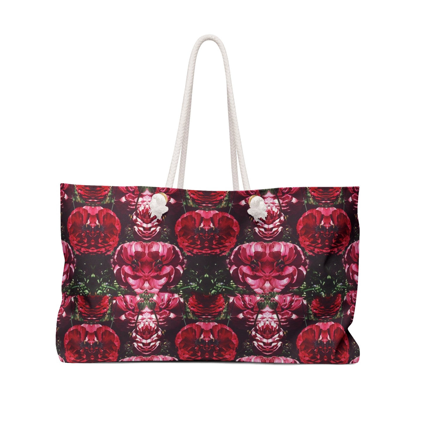 A weekender tote bag with a floral pattern in red and dark colors, featuring white handles.
