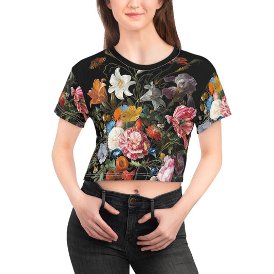 Woman wearing a black crop top with colorful floral design on a white background