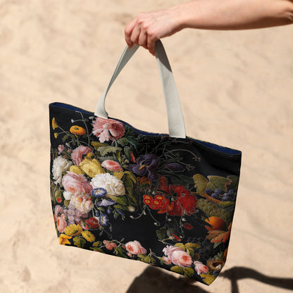 Floral tote bag held by a hand on a sandy background