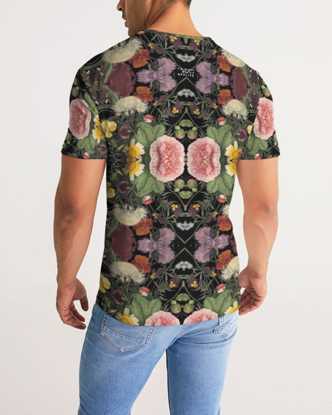 A man wearing a black botanica no. 1 men’s tee with vibrant symmetrical pink purple yellow and green floral pattern