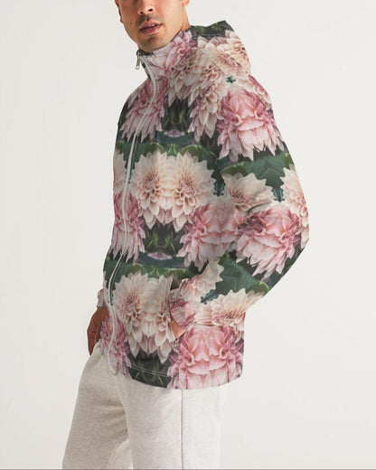 A man wearing a floralis no 26 men’s windbreaker with pink and white dahlia floral pattern on dark green leaves
